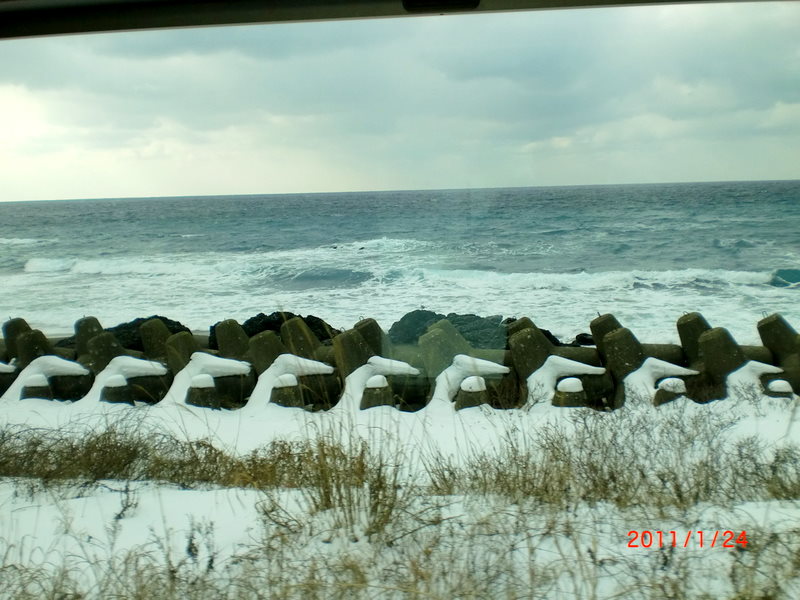 「リゾートしらかみ」の車窓からガラス越しに撮った冬の日本海